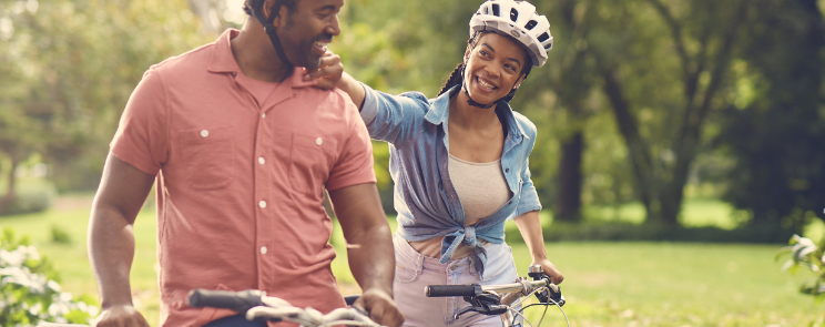 Couple walking with bicycles in the park