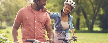 Couple walking with bicycles in the park